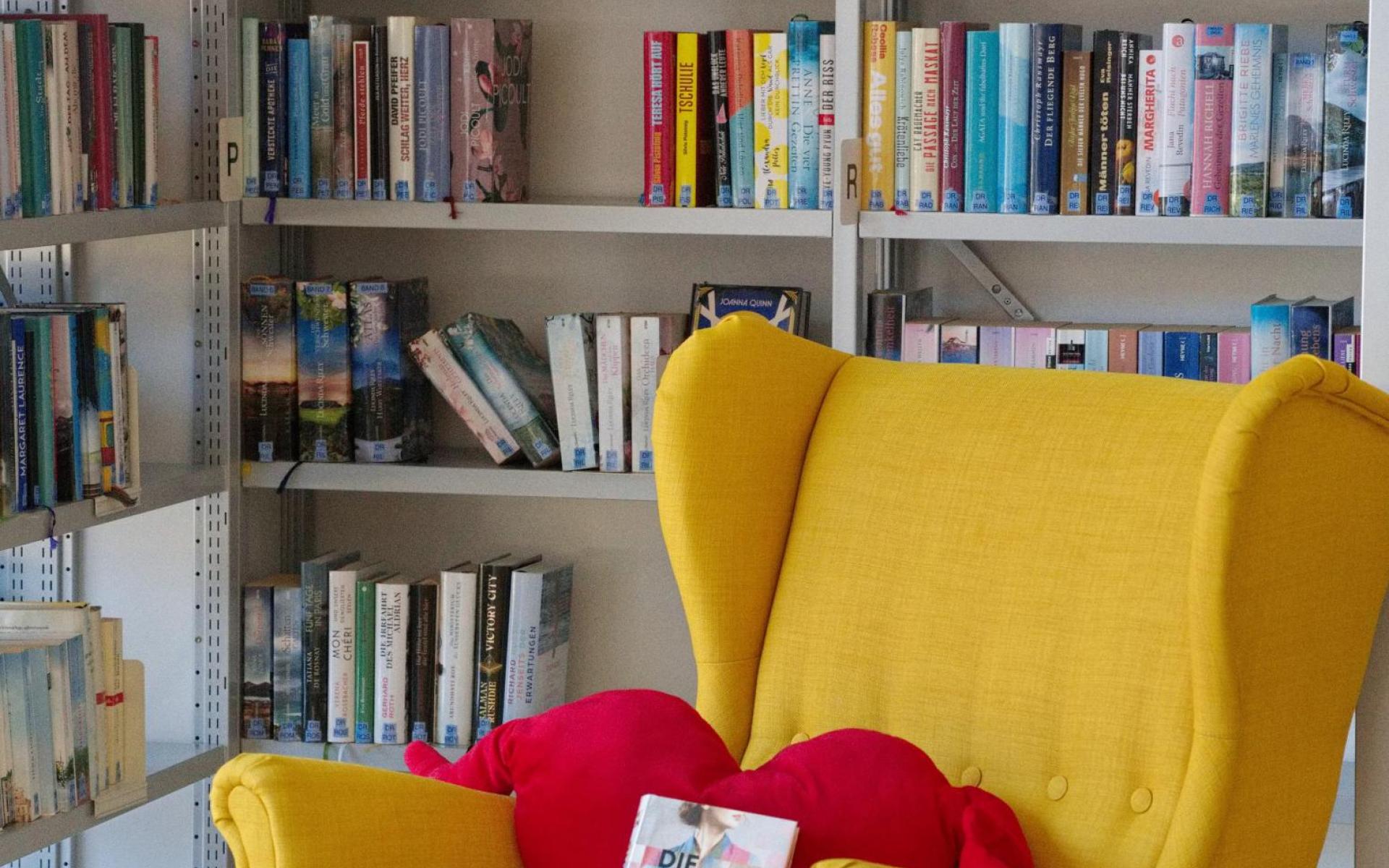 Bibliothek innen gelber Sessel 